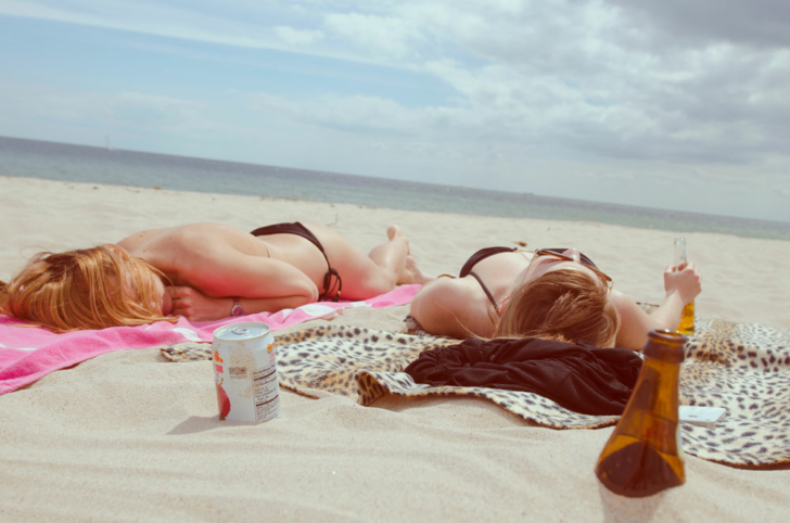 Two girls laying on the beach tanning