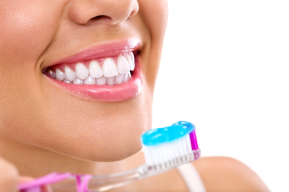 Woman brushing her teeth with whitening toothpaste